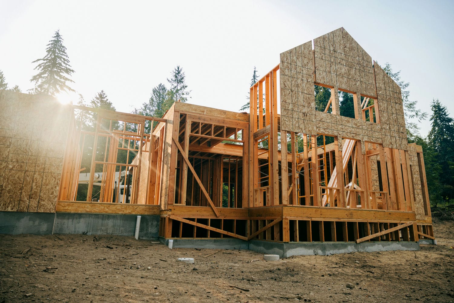 New home under construction during framing stage with timber frame going up